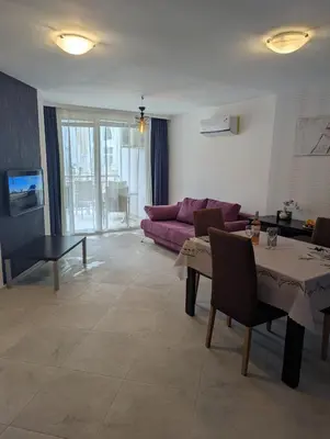 a living room with a purple couch and a table at Sunny place in Sveti Vlas