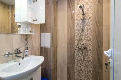 a bathroom with a sink and a shower at Central train station Flat with port view in Varna City