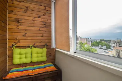a window seat with lime green pillows on a balcony at Central train station Flat with port view in Varna City