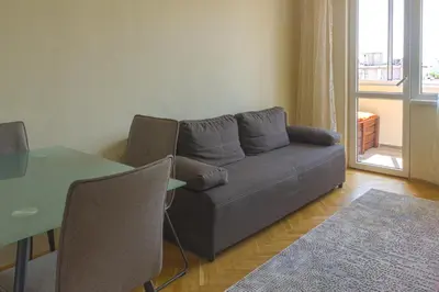 a living room with a couch and a table at Central train station Flat with port view in Varna City