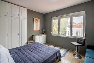a bedroom with a bed and a window and a chair at Top location in center and paid parking in Varna City