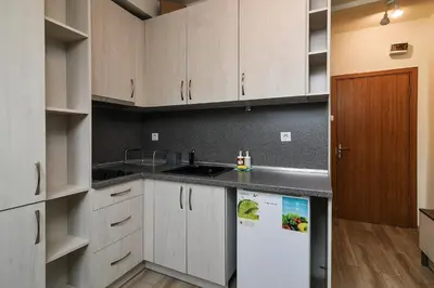 a kitchen with white cabinets and a white refrigerator at Budget studio in Varna center unde roof in Varna City