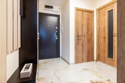 a hallway with a black door and wooden doors at M1 Pool and Beach View Apartment in Burgas City