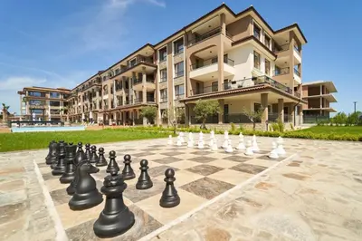 a chess board on a sidewalk in front of a building at M1 Pool and Beach View Apartment in Burgas City