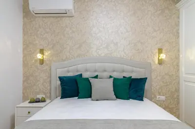 a bedroom with a white bed with blue pillows at ЛУКС НА МОРЕ Luxury apartment in downtown with garage in Varna City
