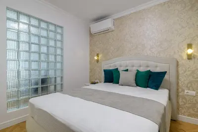 a bedroom with a white bed and a large window at ЛУКС НА МОРЕ Luxury apartment in downtown with garage in Varna City
