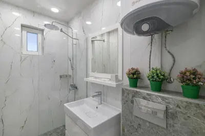 a white bathroom with a sink and a shower at ЛУКС НА МОРЕ Luxury apartment in downtown with garage in Varna City