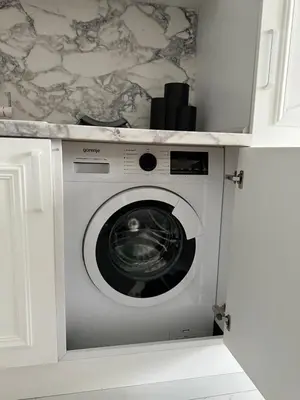 a washer and dryer in a cabinet in a kitchen at ЛУКС НА МОРЕ Luxury apartment in downtown with garage in Varna City