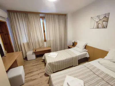a hotel room with two beds and a desk at Longoz in Bliznatsi