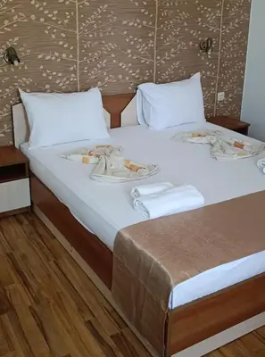 a bed with two plates of food on it at Семеен Хотел Детелини in Primorsko