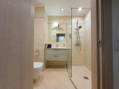 a bathroom with a toilet and a glass shower at Apartament Topalov in Burgas City