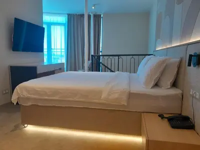 a bedroom with a large bed with a light on it at Hotel Zenith in Sunny Beach