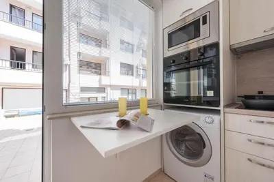 a kitchen with a washing machine and a microwave at Studio Porto in Varna City