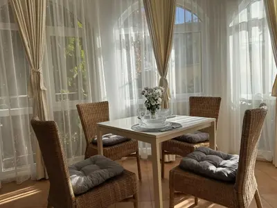 a dining room with a table and chairs and windows at Atia Resort in Chernomorets