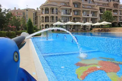 a pool with a water fountain in front of a building at Atia Resort in Chernomorets