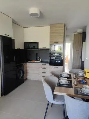 a kitchen with a table and chairs in a kitchen at Blue Heaven Apartment Kavaci Sozopol in Sozopol