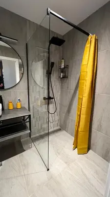 a shower with a yellow shower curtain in a bathroom at Blue Heaven Apartment Kavaci Sozopol in Sozopol