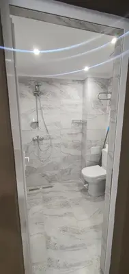 a white bathroom with a toilet and a shower at KALI GUEST ROOM in Varna City
