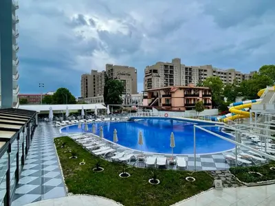 a large swimming pool with chairs and a water slide at Grand Hotel Nirvana - All Inclusive & Free Beach Access in Sunny Beach