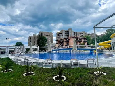 a large swimming pool with chairs and a slide at Grand Hotel Nirvana - All Inclusive & Free Beach Access in Sunny Beach