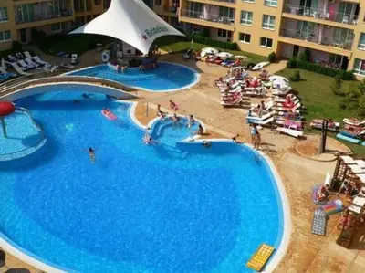a large swimming pool in a resort with people in it at Cute Studio Apt, Pollo Resort in Sunny Beach