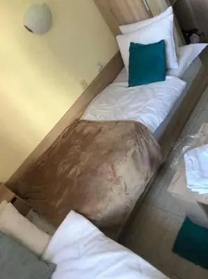 a bed in a room with a green pillow on it at Cute Studio Apt, Pollo Resort in Sunny Beach