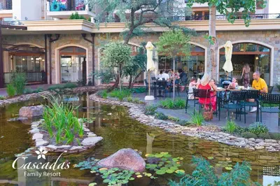 a group of people sitting at tables near a pond at Luxurious Studio Apt,4* Cascadas in Sunny Beach
