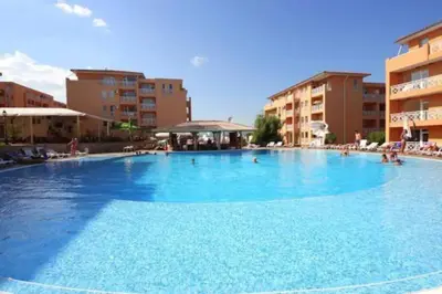 a large blue swimming pool with buildings in the background at Snug Studio Apt, Sunny Day 6 in Tŭnkovo
