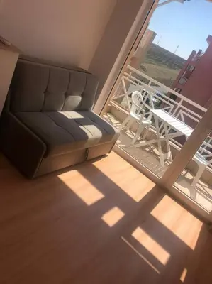 a room with a couch and a chair on a balcony at Snug Studio Apt, Sunny Day 6 in Tŭnkovo