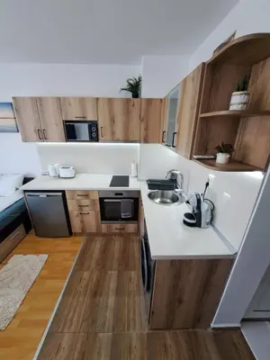 a kitchen with white counters and wooden cabinets at Апартамент за гости Магнолия Резиденс in Sunny Beach