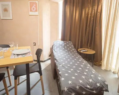 a bed in a room with a table and a table and chairs at Aleks Holiday-center,sea,parking in Burgas City