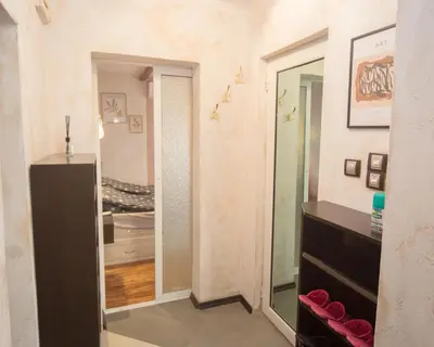 a hallway with a mirror and a dresser in a room at Aleks Holiday-center,sea,parking in Burgas City