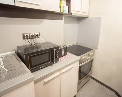 a small kitchen with a microwave and a stove at Aleks Holiday-center,sea,parking in Burgas City