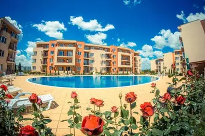 a hotel with a swimming pool and red roses at Spacious, 2 Bed Apt, Fort Orchid in Sunny Beach