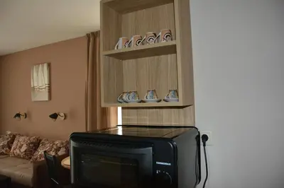 a living room with a tv and a couch at Апартаменти Детелини in Primorsko