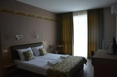 a hotel room with a bed with towels on it at Апартаменти Детелини in Primorsko