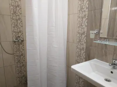 a bathroom with a shower curtain and a sink at Апартаменти Детелини in Primorsko