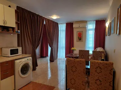 a kitchen and living room with a table and a microwave at Комплекс Элит 4 Несебр/Солнечный берег in Sunny Beach