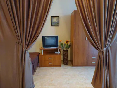 a room with a television and a curtain at Комплекс Элит 4 Несебр/Солнечный берег in Sunny Beach