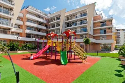 a playground in front of a large apartment building at Солнечный берег Grand Kamelia in Sunny Beach