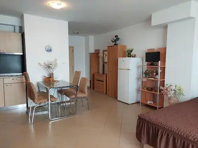 a kitchen and dining room with a table and a refrigerator at Солнечный берег Grand Kamelia in Sunny Beach