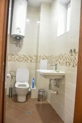 a bathroom with a toilet and a sink at Trimaya apartment - comfort in the top city center in Varna City