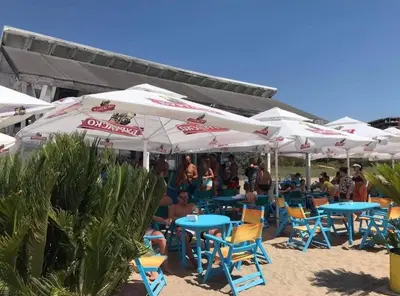 a group of tables and chairs with umbrellas on the beach at Bayview Family Garden Studio A1 in Burgas City