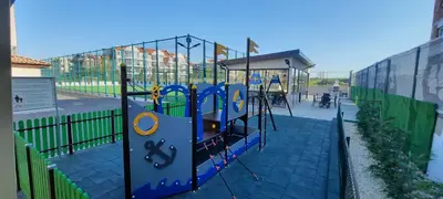 a playground with a swing set in a fence at Bayview Family Garden Studio A1 in Burgas City