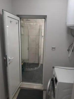 a shower with a glass door in a bathroom at Bayview Family Garden Studio A1 in Burgas City