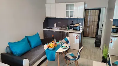 a kitchen and a living room with a couch and a table at Bayview Family Garden Studio A1 in Burgas City