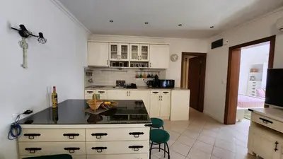 a kitchen with white cabinets and a black counter top at Nevena Summer Apartment by Santa Marina Sozopol in Sozopol
