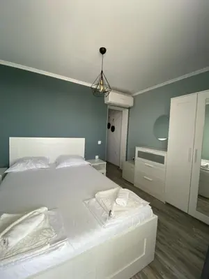 a bedroom with a white bed and a blue wall at Your Room Primorsko in Primorsko