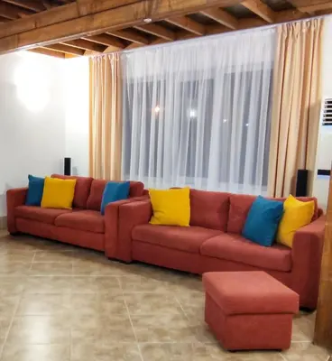 a living room with a red couch with colorful pillows at Villa Meraki in Byala