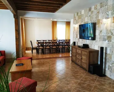 a living room with chairs and a television on a wall at Villa Meraki in Byala